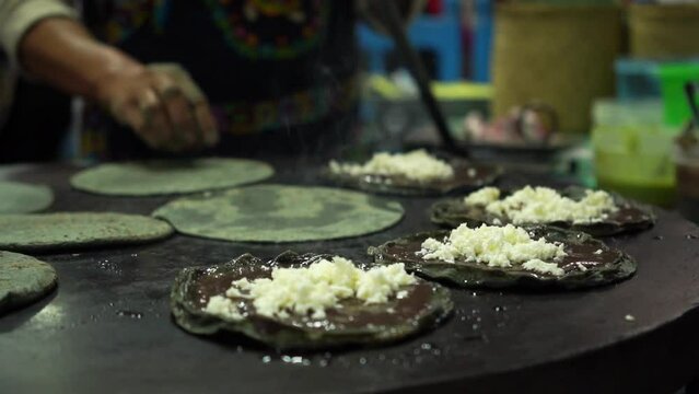 hands making a wheat tortilla on a comal