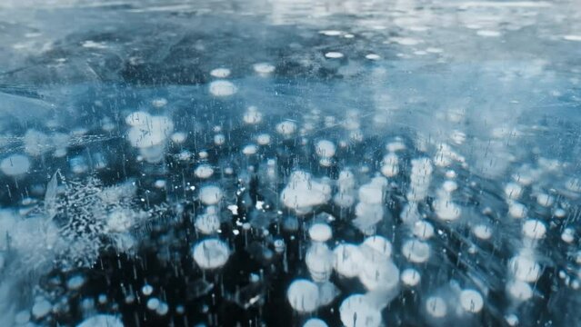 Beautiful transparent blue ice and frozen methane bubbles on Baikal Lake background texture, 4k