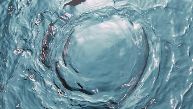 Super slow motion of water surface on light blue background. Filmed on high speed cinema camera, 1000 fps.