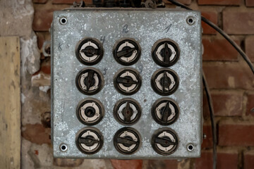 Twelve electronic switches on a control panel. Round knobs that can be turned in different...