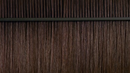 Black plastic comb combing brown hair | Hair moisturizing concept
