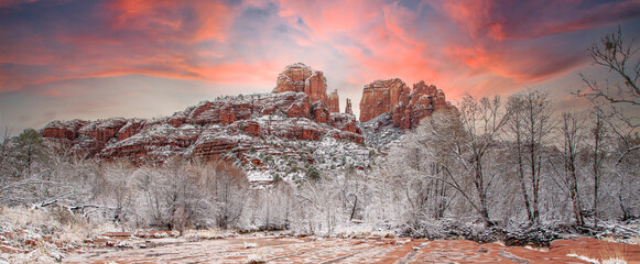 Sunset behind Cathedral rock, rising above fresh snow in the trees along Oak Creek in the red rock...