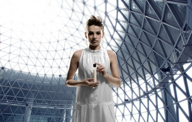 Young scientist holding test-tube standing inside geodesic dome architecture 