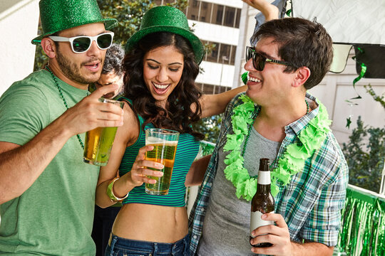 Group of friends hanging out on balcony of bar enjoying the St Patrick's Day festivities