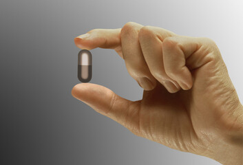 Close-up of a person's hand holding a capsule