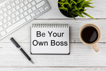 Be your own boss text on note pad on top of white office desk
