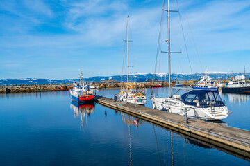 Fototapeta premium Harbour with moored sailboats and reflections in water, Trondheim, Norway