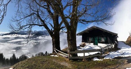 Alm H&uuml;tte mit Zaun unterhalb vom Brennkopf im Fr&uuml;hling mit Wolkenschwaden, Alpen, Tirol, &Ouml;sterreich