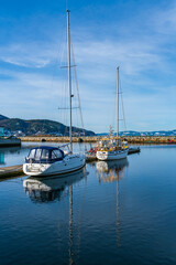 Fototapeta premium Harbour with moored sailboats and reflections in water, Trondheim, Norway