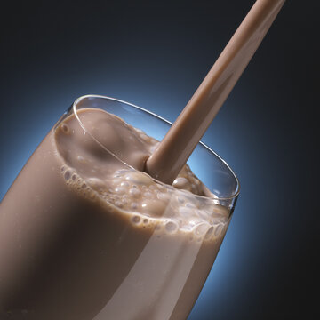 Close-up of milkshake being poured into a glass