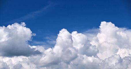 Bright landscape of white puffy cumulus clouds on blue clear sky