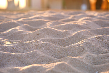 Close up of clean yellow sand surface covering seaside beach illuminated with evening light. Travel and vacations concept