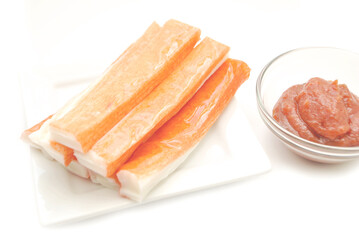 Imitation Crab Meat on a Small White Plate with Spicy Seafood Sauce