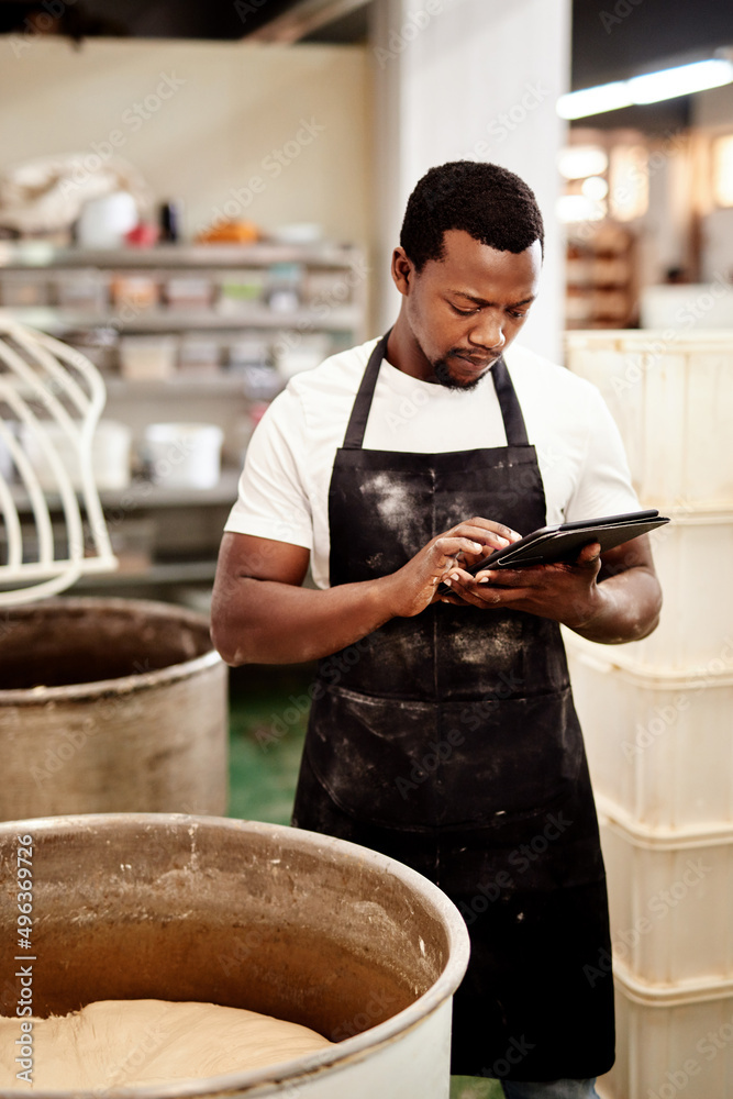 Poster I log the times for every task. Cropped shot of a man using a digital tablet while working in a bakery.