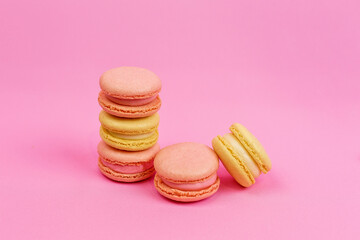 Beautiful multi-colored pastel-colored macaroons on a pink background with a place for writing and cutting. Minimalism.