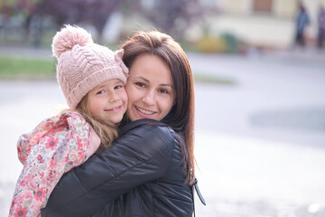 Fototapeta premium Young pretty woman hugging lovingly her child daughter. Happiness in family relations concept