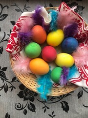 Fototapeta na wymiar Easter eggs in a wicker basket with feathers