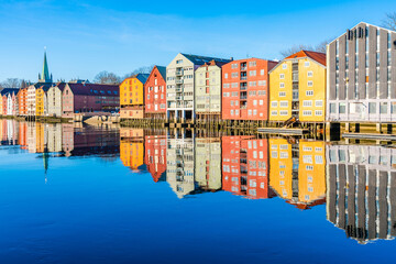 Fototapeta na wymiar Colorful old wooden houses with reflections in the river Nidelva in the Brygge district of Trondheim, Norway
