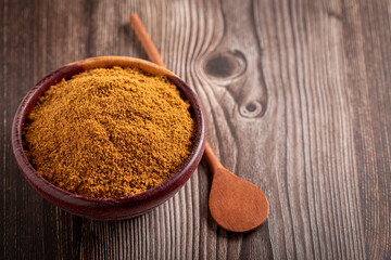 Brown sugar in wooden bowl on the table.