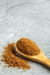 Brown sugar in wooden spoon on the table.