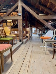 Old wooden attic with vintage chairs.