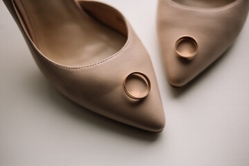 a pair of gold rings on the bride's white shoes. details of the preparation for the wedding. close-up, macro
