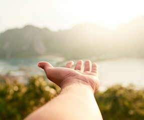 Reach for your holiday dreams. Cropped shot of an unidentifiable person holding out their hand while admiring a coastal view.