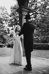 Happy young couple. Brides in hats. Young girl in a white wedding dress and hat with a bouquet of flowers. Brides in the castle. Bride and groom.