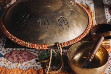 Tongue drum and Tibetan bowls lying on the carpet