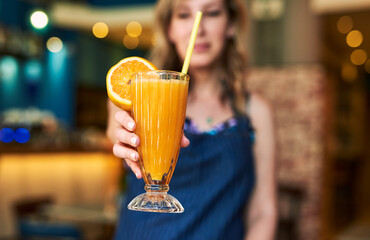 This will make you feel refreshed and revitalised. Cropped shot of a waitress holding out a drink at a bar.