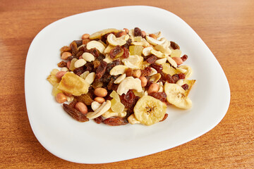 Fototapeta na wymiar Assorted fruits and nuts. Dried healthy food. Dried grapes, peanuts, pineapple, banana, cashews, almonds.