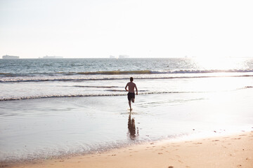 Fototapeta na wymiar man running into the sea