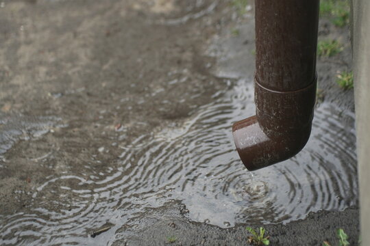 Rain Water Flows From A Plastic Drainpipe