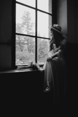 The bride in a hat and a bouquet. Portrait of a bride in a white dress. Portrait of the bride. Young girl in a white wedding dress and hat with a bouquet of flowers.