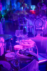 Table setup in purple light. Ready to event. Shallow dof