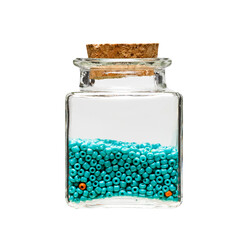 turquoise beads in a glass jar on a white background