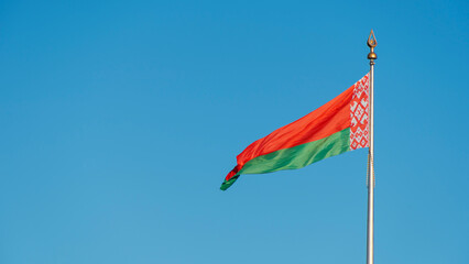 State flags of the Republic of Belarus are waving in the wind on blue sky background. Space for text.