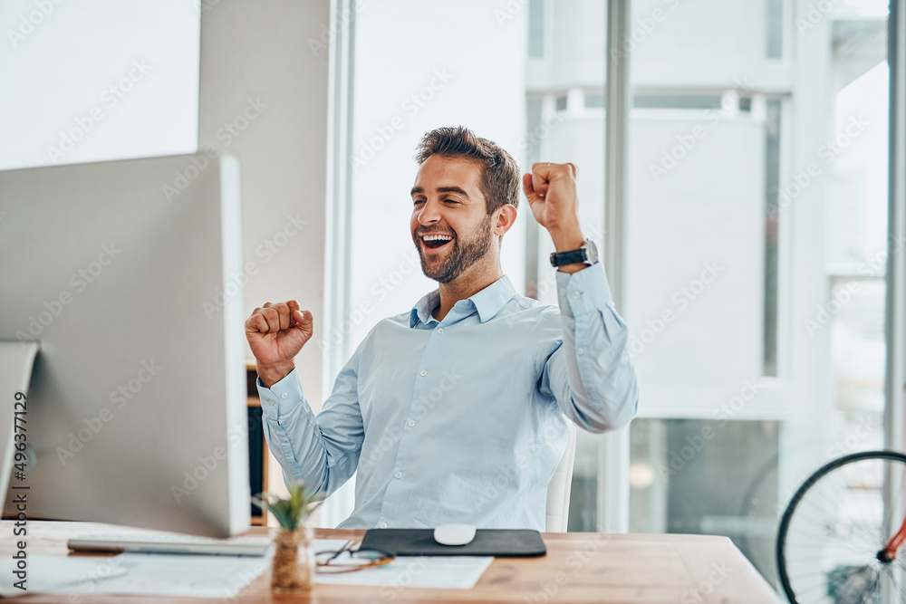 Poster what a victory. shot of a handsome young businessman doing a fist pump while working on a computer i