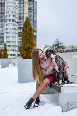 a beautiful girl in a pink leather jacket and skirt sits on a bench and hugs 