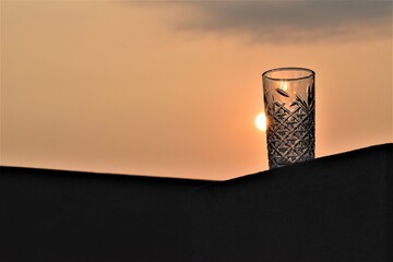 The sun peeking out from behind a glass