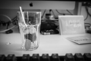 empty tea glass with a tea bag stands on a desk