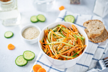 Fresh cucumber carrots salad with sesame seeds in a bowl