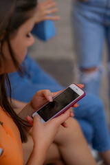 Checking her social media while sitting with her friends