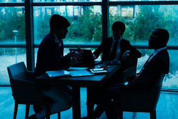 Silhouettes of business people in a conference room.