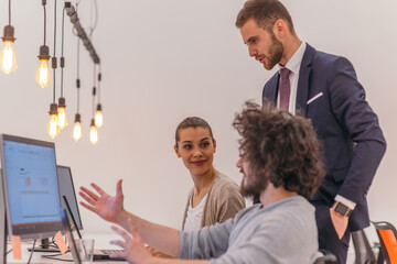 Obraz premium Manager overseeing his employees beautiful blonde and a coworker with afro haircut working in modern start up offices.