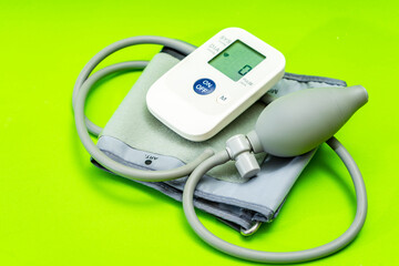 Automatic blood pressure monitor or blood pressure meter on green background. Medical equipment.