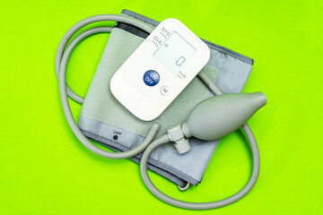 Automatic blood pressure monitor or blood pressure meter on green background. Medical equipment.