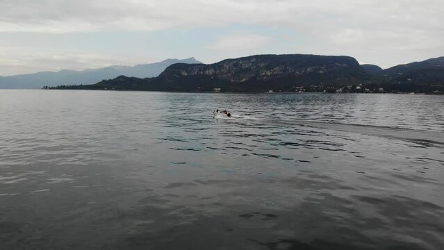 Luftaufnahme von Motorboot fahrend auf Wasser in Italien am Gardasee per Drohne gefilmt