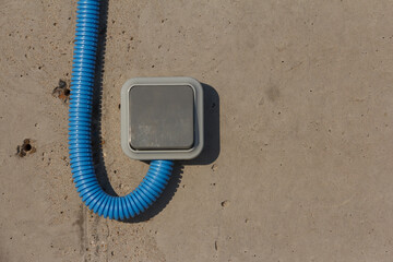 Industrial Electric Switches with protected cable on a concrete wall. Industrial lighting.