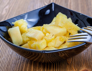 cut into pieces ripe yellow pineapple on the table